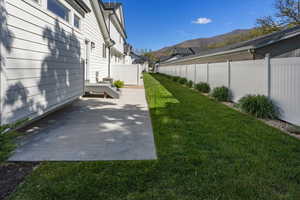 View of yard featuring fence, a residential view, and a mountain view
