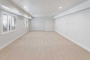 Basement featuring recessed lighting, baseboards, and light carpet