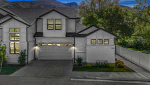Modern farmhouse style home featuring an attached garage, roof with shingles, a mountain view, and concrete driveway