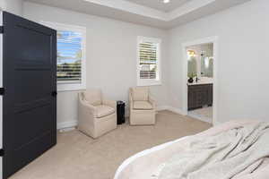 Bedroom featuring baseboards, visible vents, light carpet, and ensuite bathroom