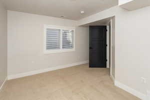 Spare room with light colored carpet, baseboards, and visible vents