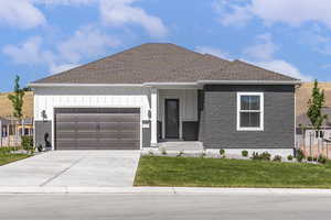 Ranch-style house featuring board and batten siding, an attached garage, driveway, and a front yard