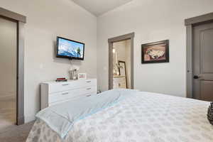 Carpeted bedroom with baseboards and ensuite bath