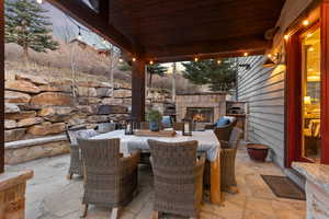 View of patio / terrace featuring an outdoor stone fireplace and outdoor dining space