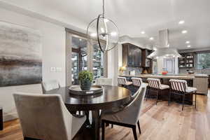 Dining area featuring light wood finished floors, recessed lighting, and a notable chandelier