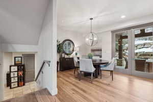 Dining area with light wood-style floors, plenty of natural light, recessed lighting, and a notable chandelier