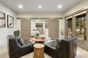 Living room with recessed lighting, a barn door, and visible vents