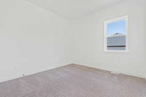 Empty room featuring baseboards, carpet flooring, and visible vents
