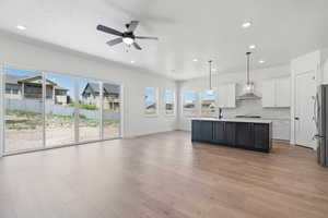 Kitchen featuring light wood-style floors, open floor plan, ceiling fan, light countertops, and white cabinetry