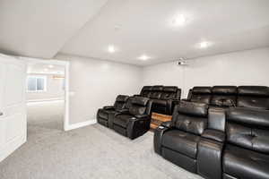 Carpeted home theater with recessed lighting and baseboards