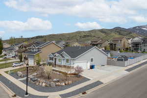 View of front of home featuring a residential view, fence, a mountain view, and concrete driveway