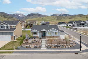 View of front of home with a residential view, fence, board and batten siding, and stone siding