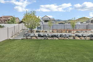 View of yard with stairs, a fenced backyard, and a residential view