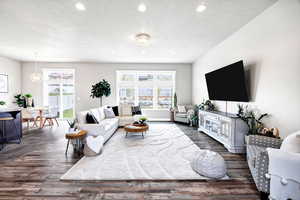 Living area with recessed lighting, dark wood finished floors, and a textured ceiling