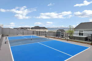 View of sport court featuring fence and a mountain view