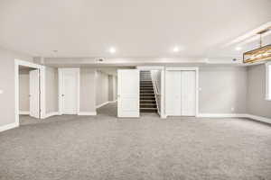 Finished basement with stairway, carpet floors, recessed lighting, and visible vents