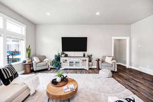 Living room featuring baseboards, visible vents, plenty of natural light, and wood finished floors
