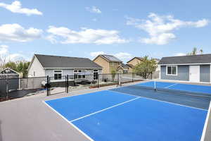 View of tennis court featuring fence and a residential view
