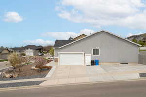 View of home's exterior featuring a garage, roof with shingles, a residential view, and concrete driveway