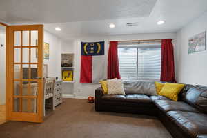 Living room with visible vents, carpet flooring, a textured ceiling, and recessed lighting