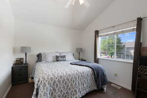 Bedroom with vaulted ceiling, baseboards, carpet flooring, and visible vents