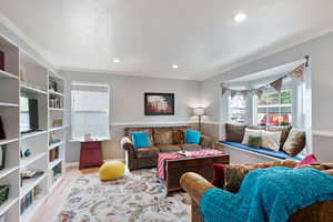 Living area featuring recessed lighting, ornamental molding, and wood finished floors