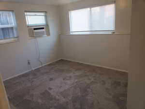 Carpeted spare room featuring baseboards