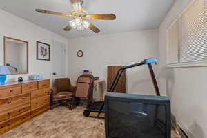 Workout room featuring a baseboard radiator, ceiling fan, and light colored carpet