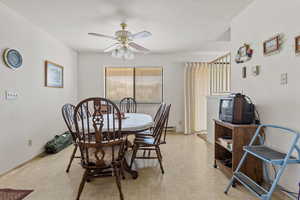 Dining area featuring a ceiling fan and light floors