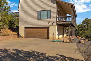 View of front of home featuring a garage, driveway, and a deck