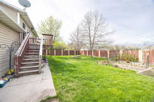View of yard with a deck, a vegetable garden, a fenced backyard, and stairs