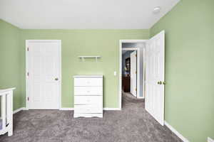 Unfurnished bedroom with carpet floors and baseboards