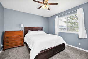 Bedroom with baseboards, a ceiling fan, and carpet flooring