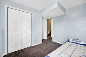 Unfurnished bedroom featuring baseboards, carpet, and a closet