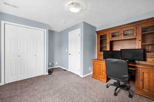 Bedroom featuring baseboards, carpet flooring, and a textured ceiling