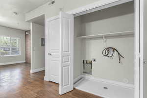 Clothes washing area with washer hookup, hookup for an electric dryer, laundry area, visible vents, and wood finished floors