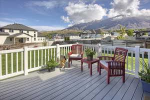 Deck with a fenced backyard, a mountain view, a yard, and a residential view