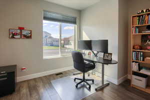 Home office with baseboards and wood finished floors