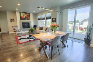 Dining space with recessed lighting, baseboards, a glass covered fireplace, and wood finished floors