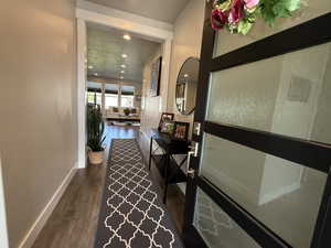 Corridor featuring baseboards, recessed lighting, and wood finished floors