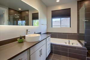 Full bath featuring vanity, a garden tub, tiled shower, recessed lighting, and tile patterned floors