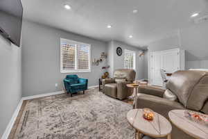 Living area with recessed lighting, baseboards, visible vents, and wood finished floors