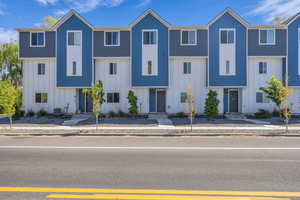 Townhome / multi-family property featuring board and batten siding and central AC