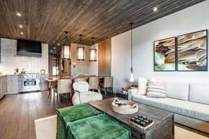 Living room featuring wood-type flooring, recessed lighting, and wooden ceiling