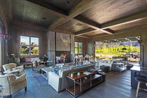 Living room featuring wood ceiling, wood-type flooring, beamed ceiling, and wood walls