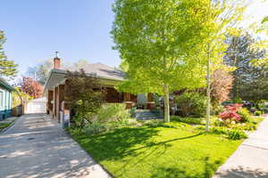 View of front of home with wood shake pillars, large porch, and front yard
