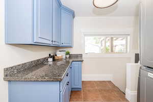 Laundry/Mud room at back of house showing included washer/dryer and cabinetry