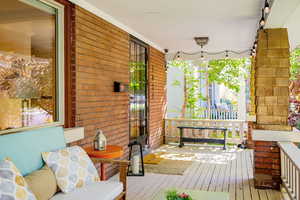 Large, covered front porch with seating and string lights