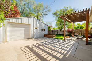 Oversized detached garage with workshop, cabinetry, overhead storage, 220 power, and entrance from driveway and rear alleyway.  Second exterior lounge area with pergola.  And oversized garden box with drip irrigation.