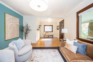 Living room featuring huge front window, and wood floors showing entryway